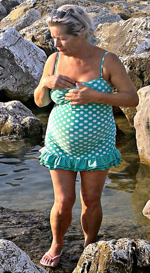 Chubby granny in a short dress on a sea