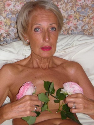 Elegant slim granny posing naked in..